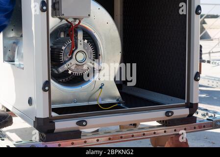 Klimageräte VRV HVAC, großer Ventilator und ein Wasserkühler auf einem Dach des neuen Industriegebäudes mit blauem Himmel und Wolken im Hintergrund. Stockfoto