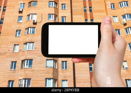 Travel Concept - touristische Fotografien der Fassade der städtischen Brick mehrstöckigen Haus in Moskau Stadt auf dem Smartphone mit leeren Ausschnitt Bildschirm mit leeren Plac Stockfoto