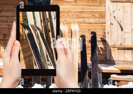 Travel Concept - touristische Fotografien der großen Jagd Skier in der Nähe von Mauer Ferienhaus aus Holz im Winter auf dem Smartphone in Smolensk Region Russlands Stockfoto