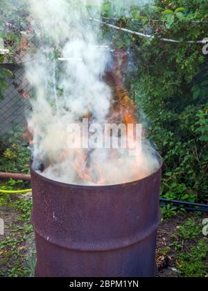 Müllverbrennung in einem alten Fass im Land Stockfoto
