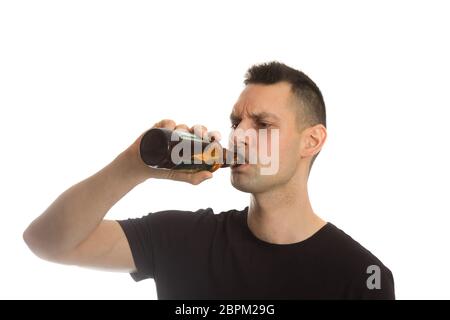 Zwangloser junger Mann trinkt eine Flasche Bier Stockfoto