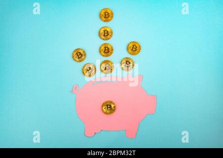 Schneiden Sie das Papier Sparschwein mit Bitcoins auf hellblauem Hintergrund Stockfoto