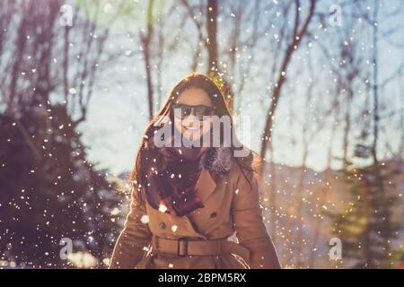 Porträt einer wunderschönen fröhliche weibliche genießen Winter Schneefall in den Park, mit Vergnügen Ausgabe Winter Urlaub im Freien Stockfoto