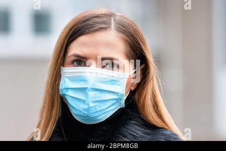 Junge Frau trägt Einweg-blauen Virus Gesicht Mund Nase Maske, Nahaufnahme Porträt. Coronavirus Covid-19 Konzept zur Prävention von Ausbrüchen Stockfoto