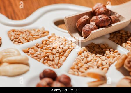 Verschiedene Nüsse, Mandeln und Getreide Körner auf weißen Maler - Paletten im flachen Winkel ansehen und kleine/Soft Focus. Stockfoto