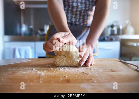 Anonyme Frau, die zu Hause in ihrer Küche frischen Teig macht, Nahaufnahme. Stockfoto