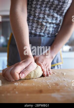 Anonyme Frau, die zu Hause in ihrer Küche frischen Teig macht, Nahaufnahme. Stockfoto