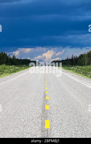 Die lange Sicht auf eine Autobahn mit einem Sturm in der Ferne. Stockfoto