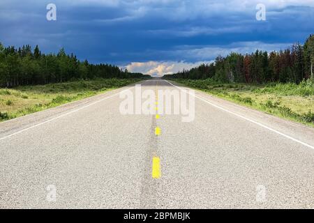 Die lange Sicht auf eine Autobahn mit einem Sturm in der Ferne. Stockfoto