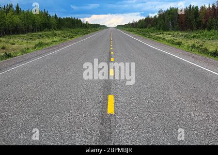 Die lange Sicht auf eine Autobahn mit einem Sturm in der Ferne. Stockfoto