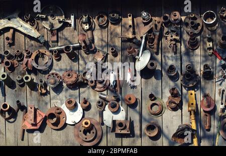 Vielen alten rostigen Auto Teile hängen an einer Holzwand. Grunge Hintergrund. Stockfoto