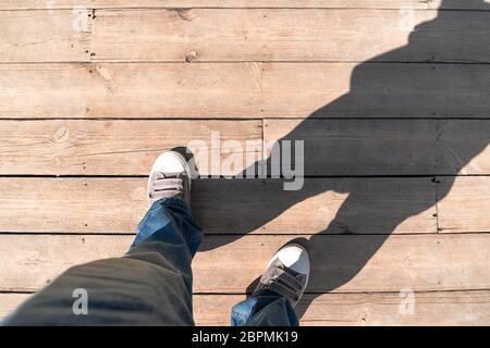 Schuhe auf Holzboden von oben, Sneaker auf Holzboden Hintergrund mit Licht und Schatten Stockfoto