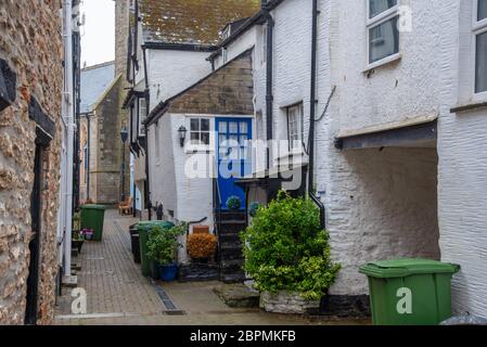 Straßenansicht in Looe am Müllabsammeltag mit schwarzen und grünen Mülltonnen an der Straßenseite. Looe ist eine kleine Küstenstadt in Cornwall, Großbritannien Stockfoto