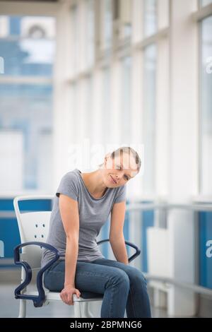 Weibliche Patienten und sitzt in einem Rollstuhl für Patienten Gefühl, nicht gut genug zu stehen, warten in einem modernen Krankenhaus (flacher Freiheitsgrade berücksichtigt werden. Stockfoto