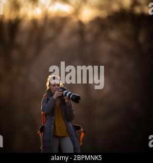 Fotografin mit Ihrer DSLR-Kamera Fotos outdoor bei Sonnenuntergang Niedlich - Fotografie, Konzept (Farbe getonte Bild) Stockfoto