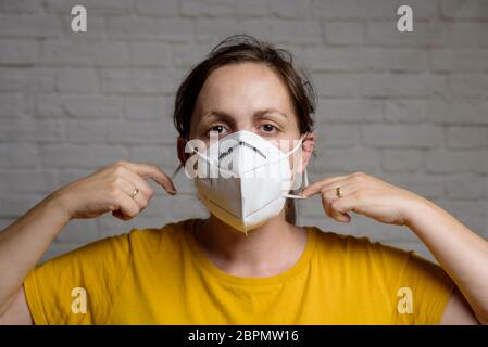 Junge Frau mit einer medizinischen Schutzmaske KN-95. Verhinderung der Ausbreitung von Virus und Epidemie, Schutz Mundfiltermaske. Krankheiten, Grippe, Luft Stockfoto