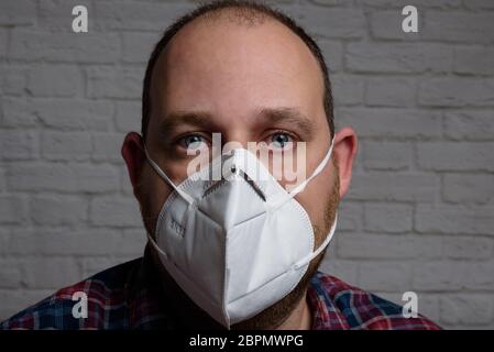 Junger Mann mit einer medizinischen Schutzmaske KN-95. Verhinderung der Ausbreitung von Virus und Epidemie, Schutz Mundfiltermaske. Krankheiten, Grippe, Luft Stockfoto