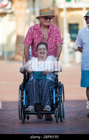 Porto Azzurro, Italien. 26. Juni 2016: Behinderte Frau im Rollstuhl. Porto Azzurro, kleine Stadt auf der Insel Elba in Italien in der Toskana. Stockfoto