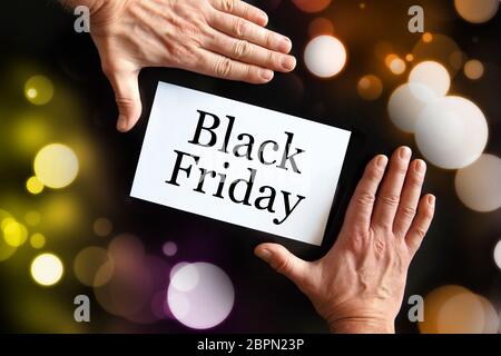 Die Hände des Mannes halten eine Karte mit der Aufschrift Black Friday Stockfoto