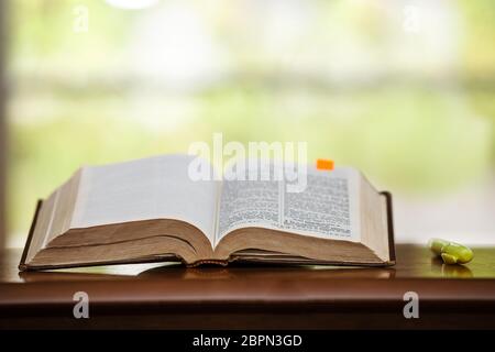 Eine spanische Übersetzung der heiligen bibel, die durch häufigen Gebrauch gut gealtert, abgenutzt und zerschlissen ist, für das Buch Daniel geöffnet und neben einem Höhepunkt Stockfoto