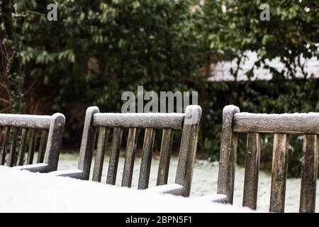 Holz- gemütlichen Garten Stühle im Schnee in einem Garten im Hinterhof abgedeckt. Wintersaison Stockfoto