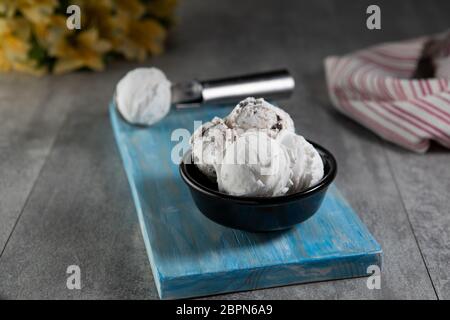 Molkerei und Stracciatella Eis in schwarzer Dessertschüssel Stockfoto