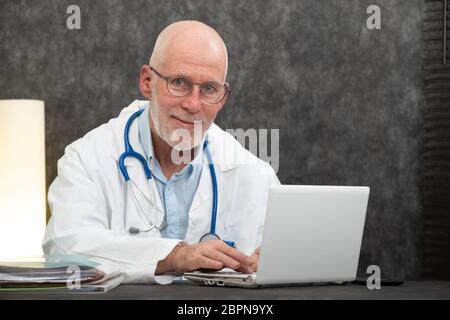Portrait von leitenden Arzt sitzen in einem medizinischen Büro Stockfoto
