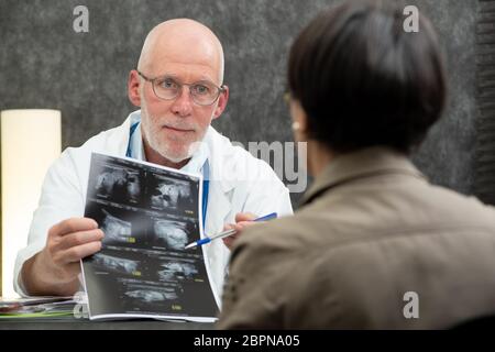 Reifen Arzt und Patientin bei Xray Suche in medizinischen Büro Stockfoto