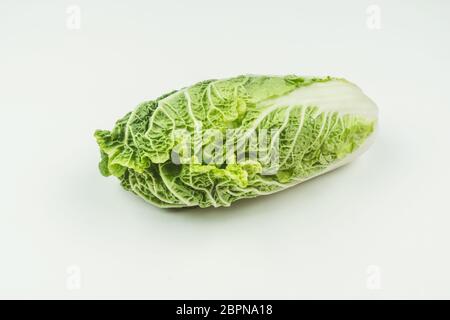 Ein Kopf aus frischem Peking Kohl auf einem hellen Hintergrund. Rohe Lebensmittel. Stockfoto
