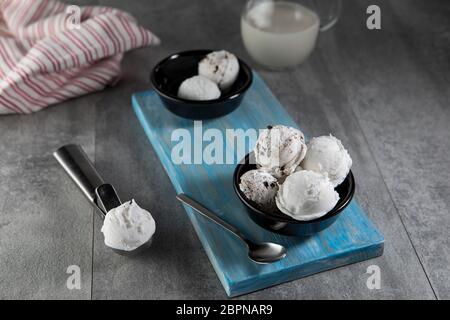 Molkerei und Stracciatella Eis in schwarzer Dessertschüssel Stockfoto
