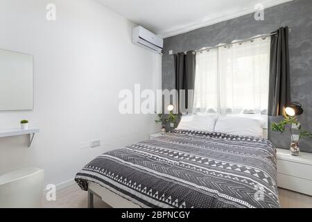 St Julians, Malta - 28. April 2020: Kleines helles Doppelzimmer mit grauem Dekor und einfachen, sauberen Wänden. Stockfoto