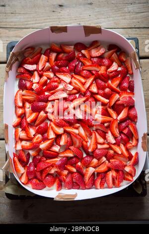 Zubereitung von Biskuitkuchen mit Sahne und Erdbeeren Stockfoto