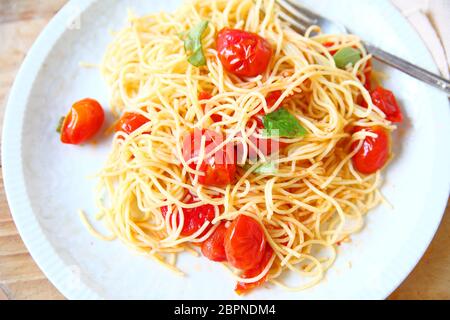 Vermicelli in einer einfachen Sauce aus Kirschtomaten, Olivenöl, Knoblauch und Basilikum Stockfoto