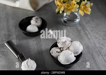 Molkerei und Stracciatella Eis in schwarzer Dessertschüssel Stockfoto