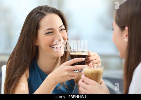 Porträt von zwei Freundinnen reden halten Kaffeetassen in einem restaurant Stockfoto