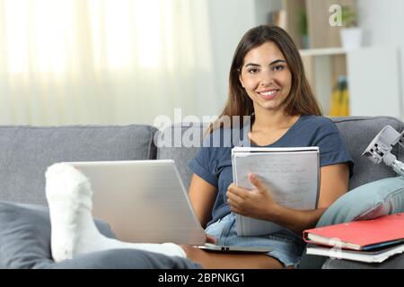 Behinderte Schüler stydying und posieren sitzen auf einer Couch im Wohnzimmer zu Hause Stockfoto