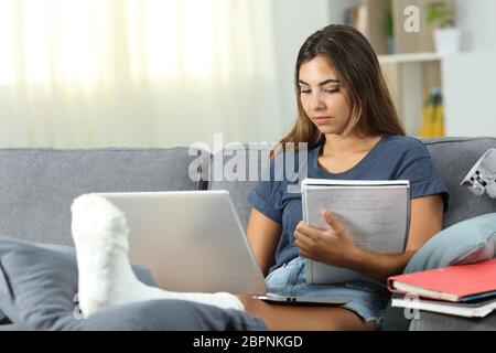 Behinderte Schüler-e-learning mit einem Laptop auf der Couch im Wohnzimmer zu Hause sitzen Stockfoto