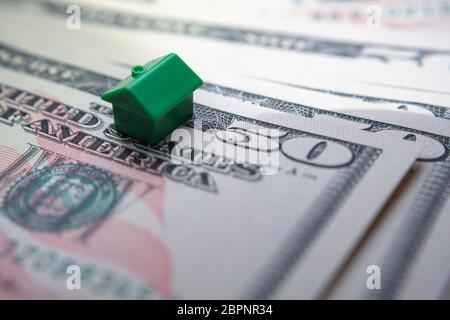 Das grüne Spielzeughaus platzierte sich auf 50 US-Dollar-Banknoten. Makrofoto. Konzept Bild für Haus Preis Index in den Vereinigten Staaten, erste Wohnung, Hypothek Stockfoto