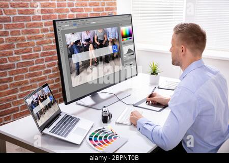 Die männlichen Designer Hand mit Grafik Tablett während der Arbeit auf mehreren Computern Stockfoto