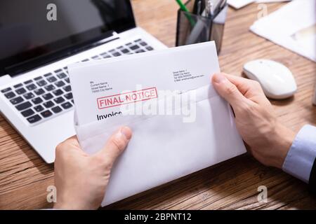 Nahaufnahme von einer Person die Hand Öffnen des Umschlags mit der endgültigen Mitteilung Rechnung in Es Stockfoto