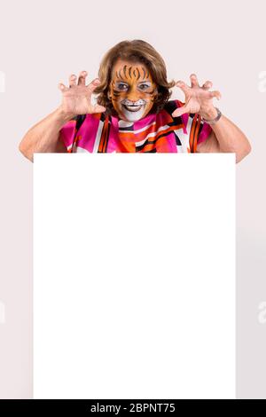 Ältere Frau mit Tiger face-Farbe über eine weiße Tafel in Weiß isoliert Stockfoto