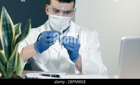 Arzt mit Spritze bereitet sich auf die Impfstoffinjektion vor und schaut auf die Nadel, Nahaufnahme. Stockfoto