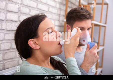 In der Nähe von Paar Leiden Asthma mit Inhalator zu Hause Stockfoto