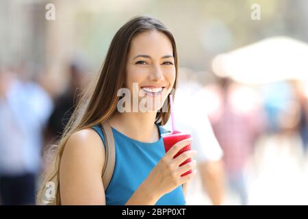 Glückliche Frau hält ein Matsch und schauen Sie auf der Straße Stockfoto