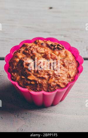 Gekochte Haferflocken Muffin in einem rosa Silikon Backformen über hellen Hintergrund. Stockfoto