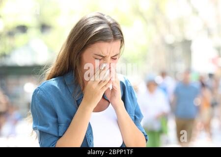 Kranke Frau Blasen auf einem Papiertuch auf der Straße an einem sonnigen Tag Stockfoto