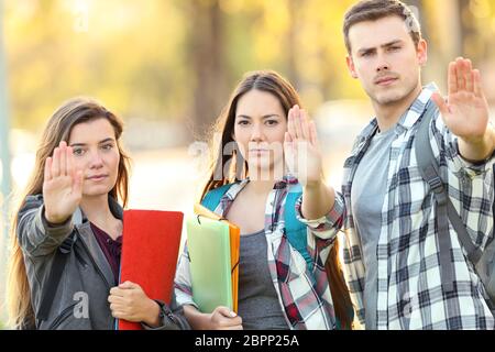 Drei wütende Studenten Gestik Stop in einem Park Stockfoto