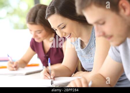 Glückliche Schüler Notizen während einer Klasse in einem Klassenzimmer Stockfoto