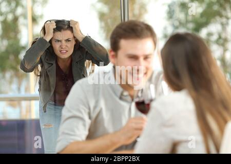 Unloyal Freund von seiner verärgerten Freundin aus mit einem anderen Mädchen in einem Restaurant gefangen Stockfoto