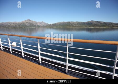 Deck & Geländer eines Schiffes, wenn es Fjorde, Inseln und Innenpassagen kreuzt; der Andfjorden & Vestfjorden, zwischen Bodo & Hammerfest, Norwegen. Stockfoto